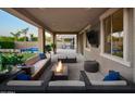 Stylish outdoor living space with comfortable seating, a cozy fire pit, and a mounted television at 2854 E Virginia St, Mesa, AZ 85213