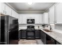 Well-equipped kitchen with granite countertops, white cabinets, and sleek black appliances at 29606 N Tatum Blvd # 245, Cave Creek, AZ 85331