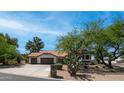 Charming single-Gathering home featuring a terracotta roof, three-car garage, desert landscaping, and a stone-accented facade at 35 E Secretariat Dr, Tempe, AZ 85284
