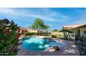 Inviting backyard pool featuring a rock waterfall, lush landscaping, and a private setting at 35 E Secretariat Dr, Tempe, AZ 85284