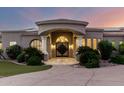 Grand entrance with a covered porch, stone pillars, solar panels, and an elegant front door at 402 E Windmere Dr, Phoenix, AZ 85048