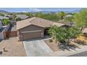 Charming single-story home featuring a neutral color palette, desert landscaping, and a two car garage at 4125 W Gary Way, Laveen, AZ 85339