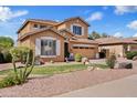 Charming two-story home features desert landscaping and an inviting facade under a clear blue sky at 4976 E Thunderbird Dr, Chandler, AZ 85249