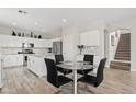 Bright, modern kitchen featuring white cabinets, stainless appliances, and a glass-top dining table at 4976 E Thunderbird Dr, Chandler, AZ 85249