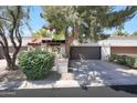 Charming home featuring a two-car garage, mature trees, and meticulously maintained landscaping at 7368 E Pleasant Run, Scottsdale, AZ 85258