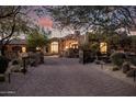 Gated driveway leading to the home with lush desert landscaping and stone accents at 7552 E Whisper Rock Trl, Scottsdale, AZ 85266