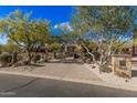 Long driveway leading to a custom home with mature desert landscaping at 7552 E Whisper Rock Trl, Scottsdale, AZ 85266