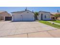 Home exterior featuring a well-kept lawn, two-car garage, and tile roofing, set under a sunny sky at 1062 N Robin Ln, Mesa, AZ 85213