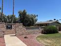 Well-maintained community entrance sign with mature trees and manicured landscaping at 13603 N 111Th Ave, Sun City, AZ 85351