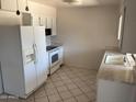 Bright kitchen with white appliances and tile flooring at 13603 N 111Th Ave, Sun City, AZ 85351