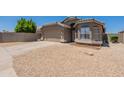 Charming single-story home featuring a two-car garage and desert landscaping at 15128 W Melissa Ln, Surprise, AZ 85374