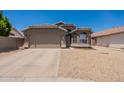 Charming single-story home featuring a two-car garage and desert landscaping at 15128 W Melissa Ln, Surprise, AZ 85374