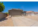 Charming single-story home featuring a two-car garage and desert landscaping at 15128 W Melissa Ln, Surprise, AZ 85374
