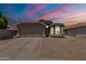 Charming single-story home featuring a two-car garage, gravel landscaping, and neutral-toned exterior paint at 15128 W Melissa Ln, Surprise, AZ 85374