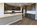Spacious kitchen featuring white backsplash, wooden cabinetry, a large island and hard surface floors at 17493 W Fulton St, Goodyear, AZ 85338