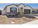 Charming single-Gathering home with a well-manicured front yard and a two-car garage, showcasing modern architecture at 17778 W Turquoise Ave, Waddell, AZ 85355