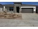 An inviting single-story home with stone accents, a two-car garage, and low-maintenance landscaping at 17778 W Turquoise Ave, Waddell, AZ 85355