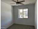 Neutral bedroom with a ceiling fan, plush carpet, and natural light from a window at 18361 W Jessie Ln, Surprise, AZ 85387