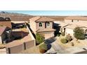 Aerial view of a terracotta roof home with a two-car garage, lush landscaping, and a fenced backyard at 19886 W Woodlands Ave, Buckeye, AZ 85326