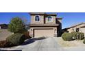 Charming home featuring a two-car garage, arched windows, and well-maintained landscaping at 19886 W Woodlands Ave, Buckeye, AZ 85326