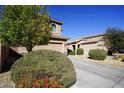 Attractive home showcasing a two-car garage, manicured landscaping, and healthy, green shrubbery at 19886 W Woodlands Ave, Buckeye, AZ 85326
