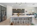 Kitchen features a large island with seating, stainless steel appliances, gray cabinets, and pendant lighting at 21134 W Minnezona Ave, Buckeye, AZ 85396