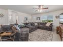 Comfortable living room with a large sectional sofa, ceiling fan, and natural light at 22578 E Sahara Dr, Florence, AZ 85132