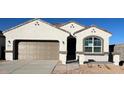 Charming single-Gathering home featuring a two-car garage, stone accents, and manicured landscaping at 25478 W Graham Trl, Buckeye, AZ 85326