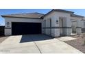 Beautiful single-story home featuring stone accents, manicured front yard, and an attached two-car garage at 25481 W Graham Trl, Buckeye, AZ 85326