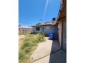 Exterior shot of backyard featuring sparse grass, concrete walkway, and tall fencing at 3308 W Missouri Ave, Phoenix, AZ 85017