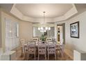 Elegant dining room with a glass top table, seating for eight, and modern lighting at 3350 E Rosemonte Dr, Phoenix, AZ 85050