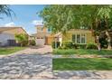 Charming two-story home with a paver driveway, mature trees, and well-maintained landscaping at 4109 E Sierra Madre Ave, Gilbert, AZ 85296