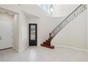 Bright foyer featuring a grand staircase, soaring ceilings, tile flooring, and a decorative front door at 4109 E Sierra Madre Ave, Gilbert, AZ 85296