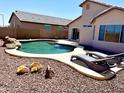 Resort style backyard with sparkling pool, decorative rock, lounge chairs and low maintenance landscaping at 5749 S 247Th Dr, Buckeye, AZ 85326