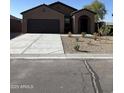 Single-story home featuring desert landscaping, dark brown stucco and spacious driveway at 5782 E Orion Rd, Florence, AZ 85132