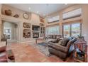 Spacious living room featuring high ceilings, terracotta tile flooring, and a cozy fireplace at 5892 E Carefree Mountain Dr, Carefree, AZ 85377
