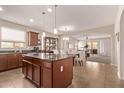 Open-concept kitchen with a central island, stylish pendant lighting, and seamless flow to the dining area at 729 W Silver Reef Dr, Casa Grande, AZ 85122