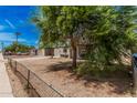 A tranquil neighborhood street with lush trees surrounding cozy, single-story residences at 7746 W Osborn Rd, Phoenix, AZ 85033