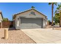 Attached single-story home with a gray two-car garage and desert landscaping at 7924 W Hammond Ln, Phoenix, AZ 85043