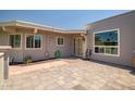 Inviting backyard patio featuring pavers and a charming entrance with stylish details at 10643 W Pineaire W Dr, Sun City, AZ 85351