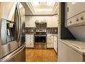 Updated kitchen features stainless steel appliances, stylish backsplash, granite countertops, and laminate flooring at 11026 N 28Th Dr # 34, Phoenix, AZ 85029