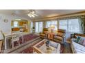 Bright living room with display shelving, a ceiling fan, and views into the kitchen at 111 S Greenfield Rd # 467, Mesa, AZ 85206