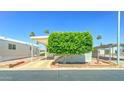Charming mobile home with a mature shade tree in the front yard, covered parking, and landscaping at 111 S Greenfield Rd # 531, Mesa, AZ 85206