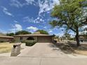Charming single-story home featuring a brick facade, well-manicured lawn, and an arched entryway at 1118 E Orangewood Ave, Phoenix, AZ 85020