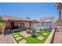 Inviting backyard featuring a pool, fire pit, pergola and an artificial turf area for outdoor relaxation and entertainment at 11252 E Edgewood Ave, Mesa, AZ 85208