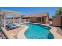 Sparkling pool area featuring a unique pool design, lounge chairs, and a pergola for shaded relaxation at 11252 E Edgewood Ave, Mesa, AZ 85208