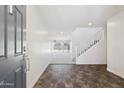 Bright foyer boasts dark flooring and leads into a living space with a staircase visible at 12531 W Glenn Dr, Glendale, AZ 85307