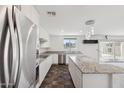 Modern kitchen with stainless appliances, granite countertops, and large island open to living area at 12531 W Glenn Dr, Glendale, AZ 85307