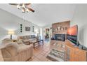 Cozy living room with brick fireplace, tile flooring, plush sofa, and sliding glass doors at 13219 N 26Th Ave, Phoenix, AZ 85029