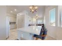 Bright kitchen with a center island, pendant lighting, and a seamless flow into the adjacent dining and living areas at 16537 N Oachs Dr, Surprise, AZ 85374